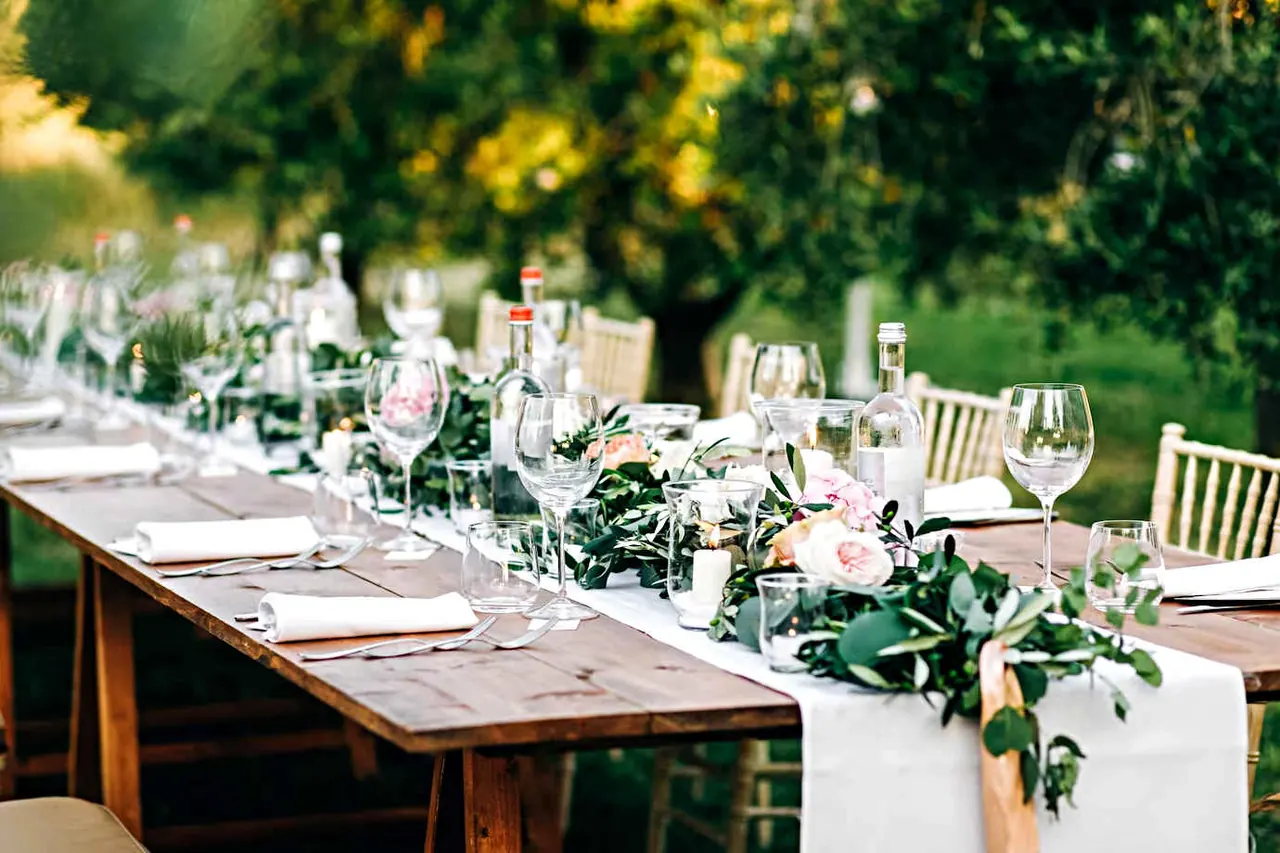 Table de réception champêtre dressée en extérieur au milieu de la verdure en Gironde