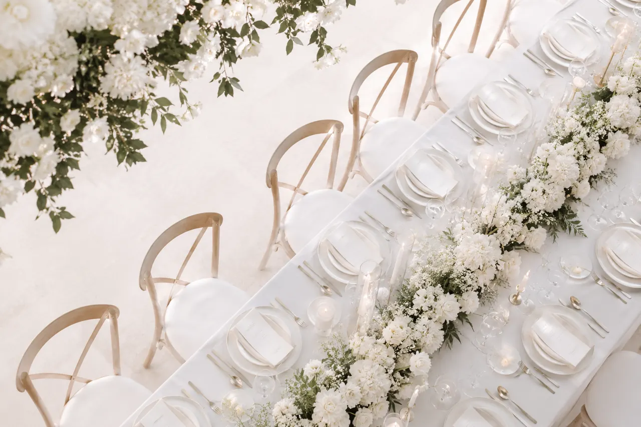Grande table de mariage blanc et lin ornée de fleurs blanches, dressée par Orore Event, wedding planner en Gironde